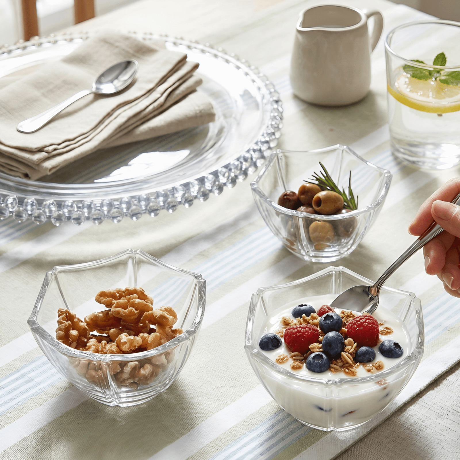 Boluri din sticlă Veselo Crystal cu iaurt și cereale pe o masă de mic dejun luminoasă.