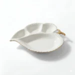 Detaliu margine aurie lucrată manual pe platou de ceramică albă